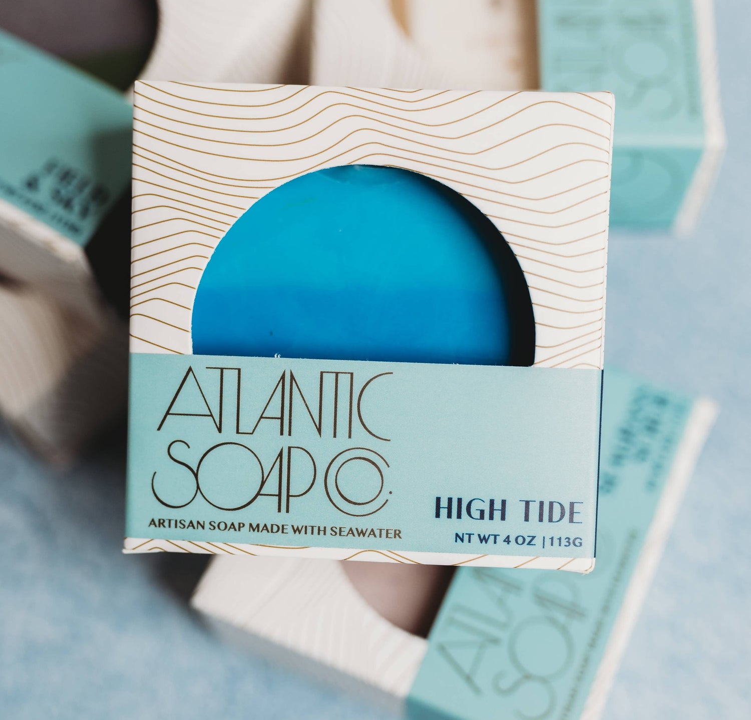 Blue soap bar in a packaging box with 'Atlantic Soap Co' branding on a light blue background.